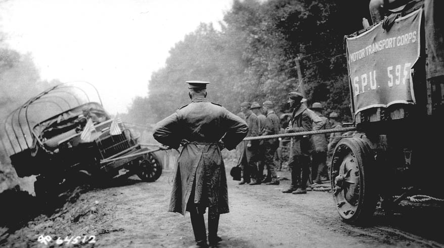 During the 1919 transcontinental convoy, west of Grand Island, Nebraska, soldiers use a winch to pull a Class B truck out of a ditch. Lt. Col. P. V. Kieffer surveys the scene. (Eisenhower Library)