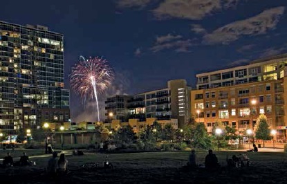 Riverfront Park at night, with Park Place Lofts on the right, the Glass House on the left, and Commons Park in the foreground. The park offers a highly attractive amenity directly adjacent to the project.