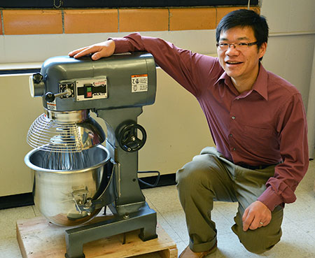 Xianming Shi with the industrial size mixer he uses to concoct green deicers and ice-free pavement. (Photo by Rebecca Phillips, University Communications)