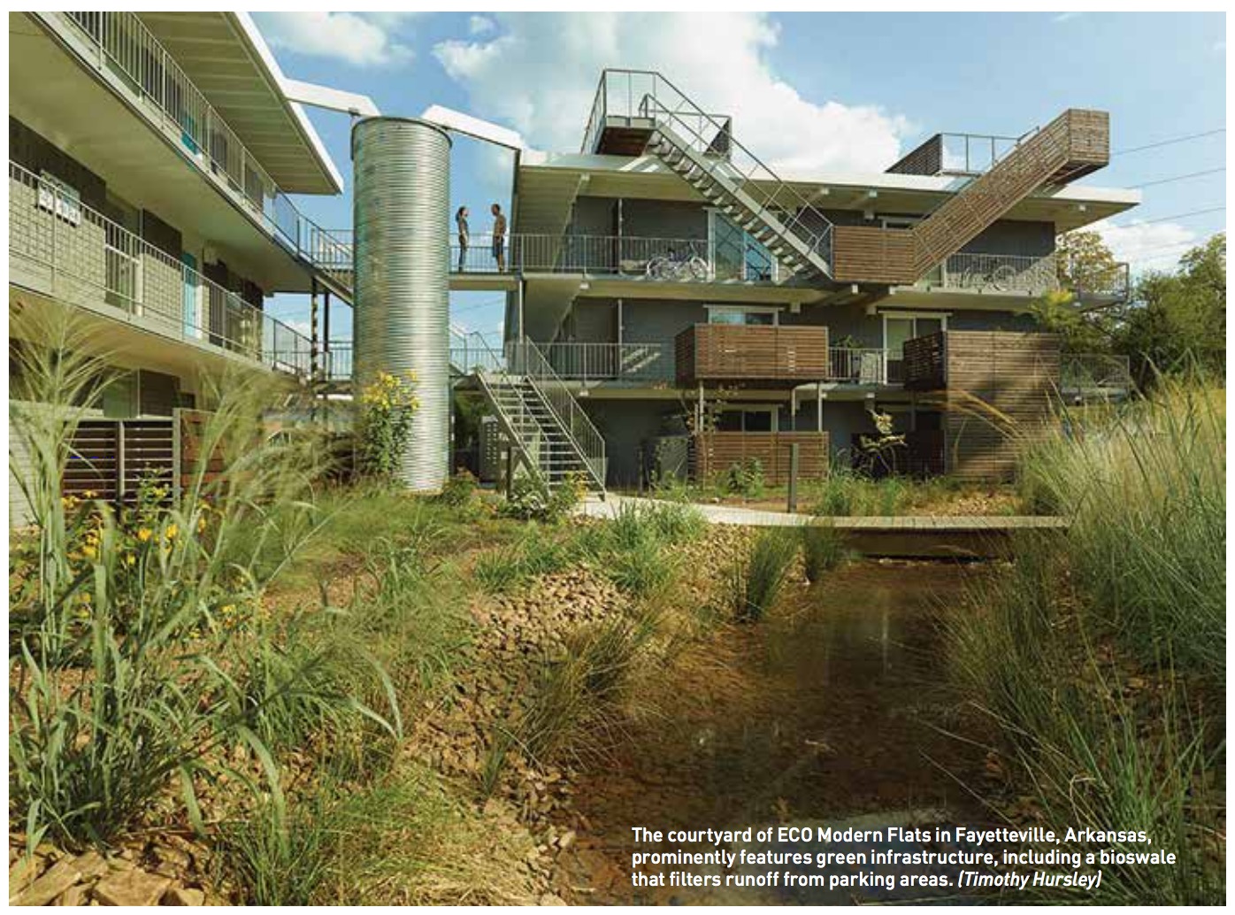 The courtyard of ECO Modern Flats in Fayetteville, Arkansas, prominently features green infrastructure, including a bioswale that filters runoff from parking areas. (Timothy Hursley)